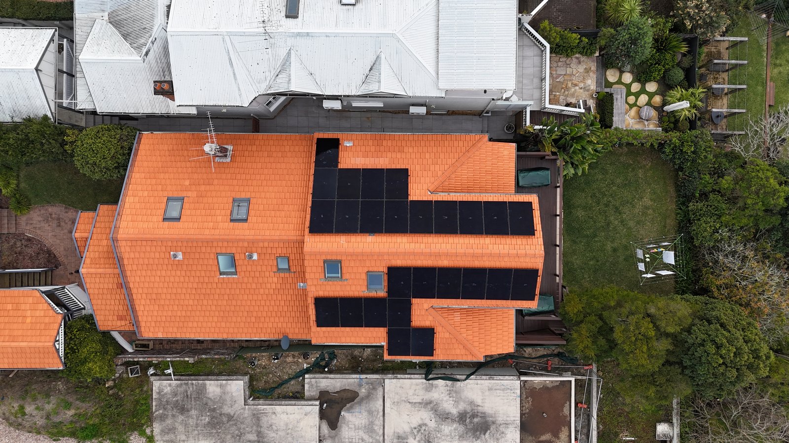 Aerial view of a terracotta tile roof solar installation in Mosman with sleek black panels