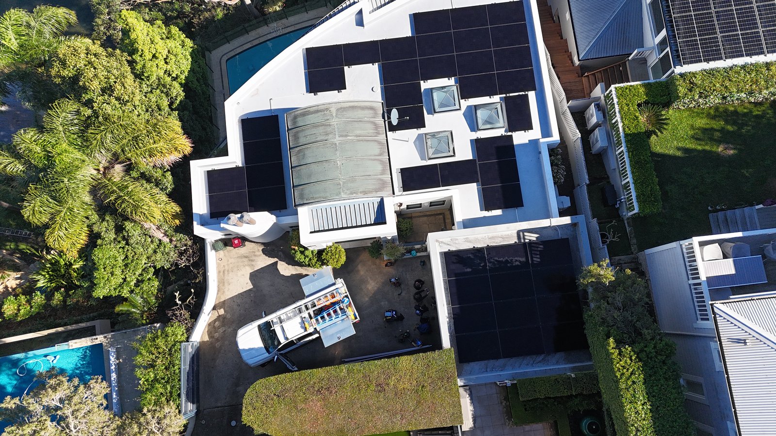 Aerial view of a Northwood home with pool and rooftop solar, Infinite work van on site