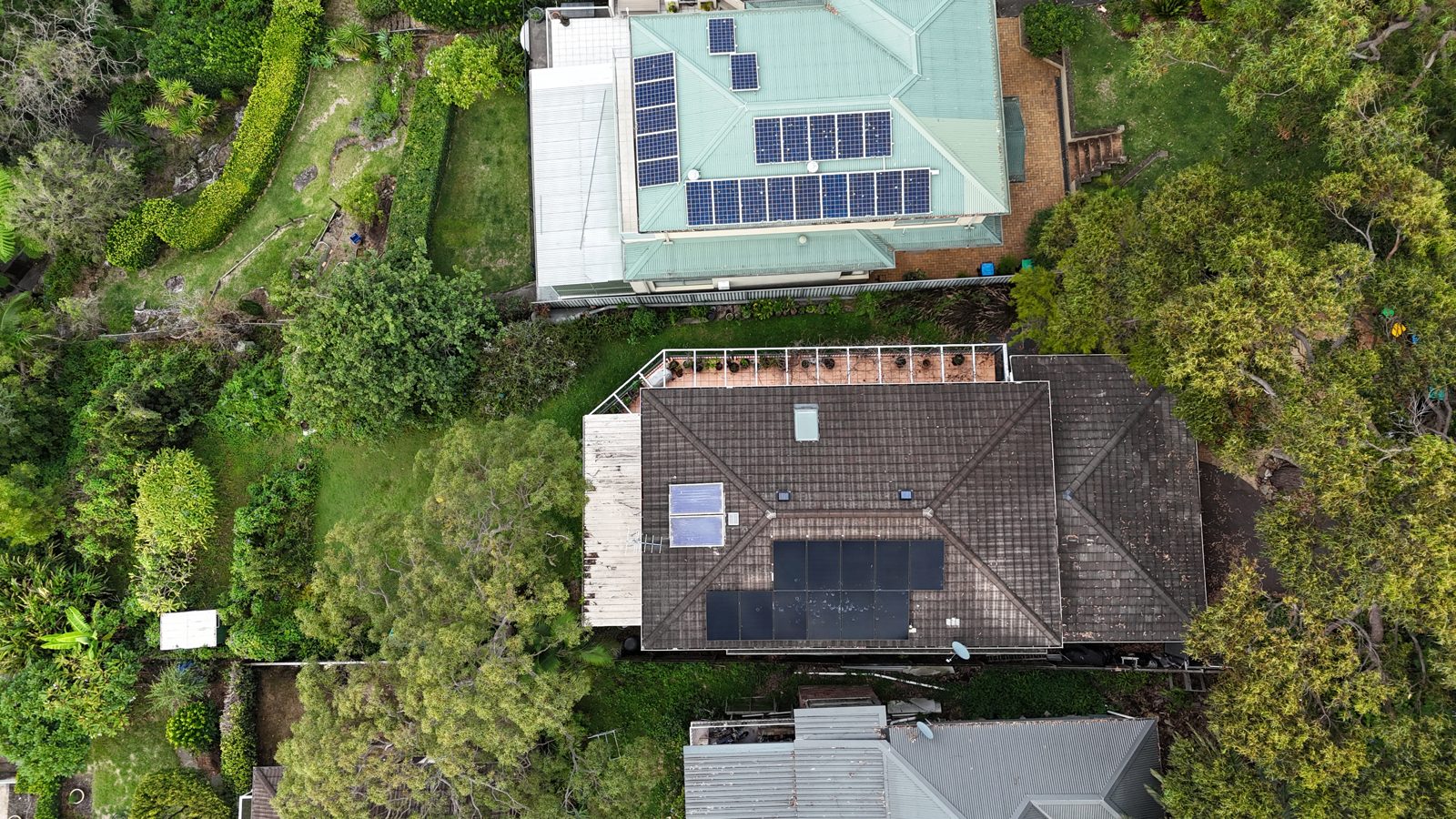 Aerial view of a home framed by garden greenery with solar panels installed