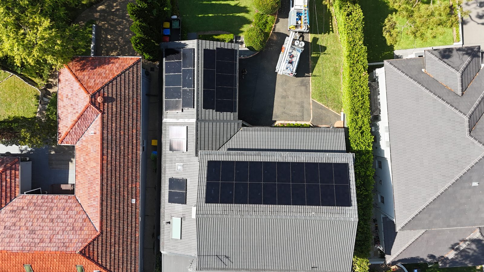 Aerial view of a home with solar panels and a tennis court in the grounds