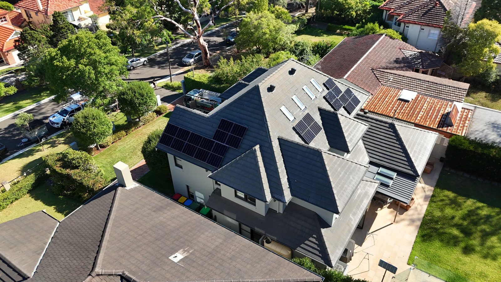 Aerial view of a home on a tree-lined street with rooftop solar panels