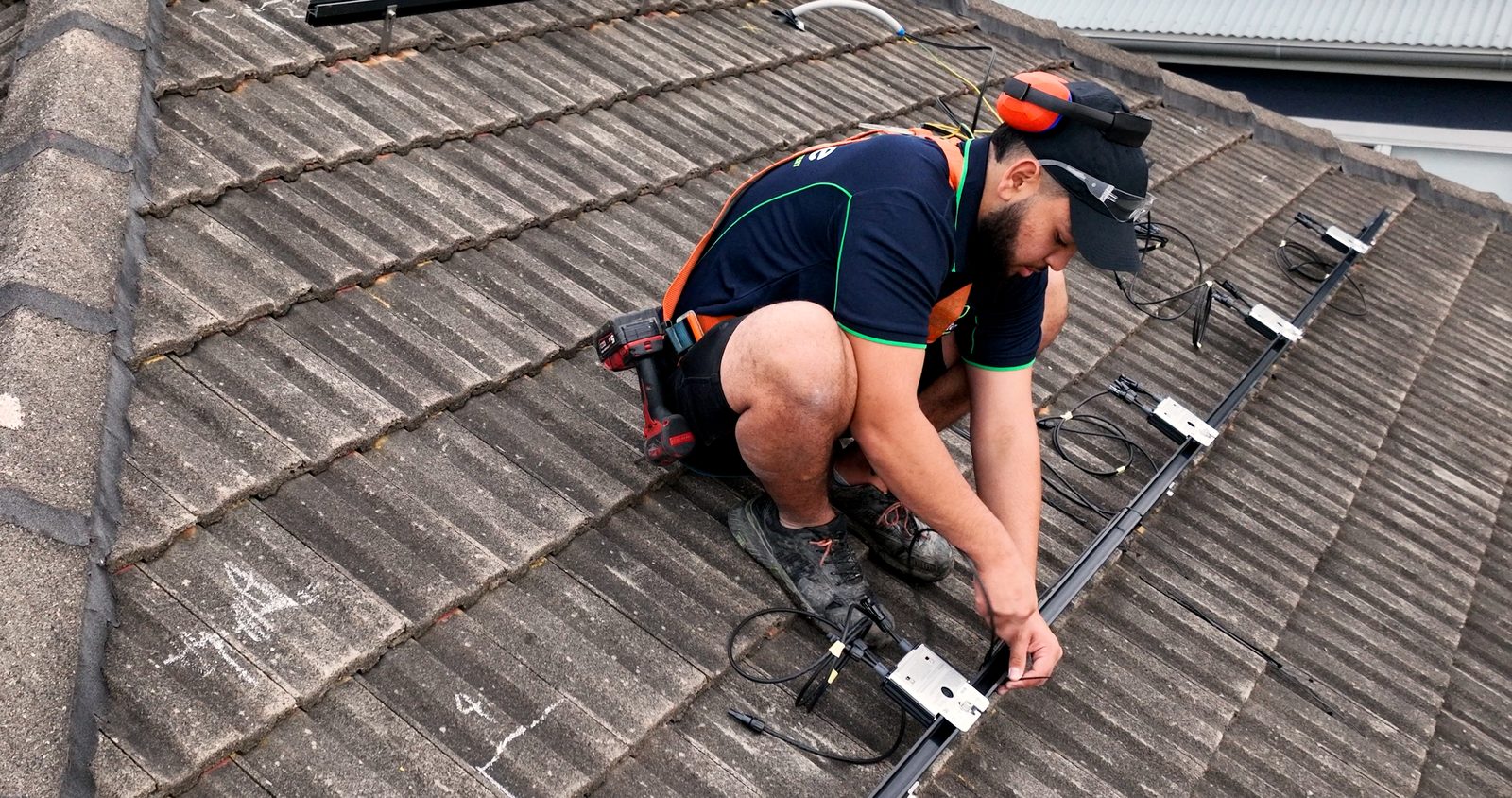 Installer fitting mounting rails and cabling ahead of solar panel installation